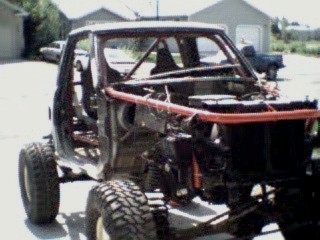 Tied it into the internal rollcage.  This was tough as I had to remove the dash, cut out part of the cowl and penetrate the firewall.  I busted out the windshield to make it easier the weld. The windsheild had welding splatter all over anyways.